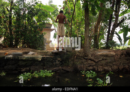 Lave-garçon à côté de la rivière dans les backwaters près de Alleppey Banque D'Images