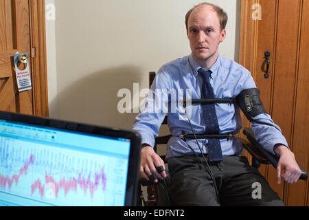 L'homme en cours d'examen à l'aide d'un polygraphe détecteur de mensonge machine qui compare les réponses à certaines des questions pour obtenir la vérité Banque D'Images