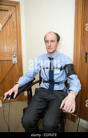 L'homme en cours d'examen à l'aide d'un polygraphe détecteur de mensonge machine qui compare les réponses à certaines des questions pour obtenir la vérité Banque D'Images