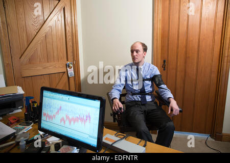 L'homme en cours d'examen à l'aide d'un polygraphe détecteur de mensonge machine qui compare les réponses à certaines des questions pour obtenir la vérité Banque D'Images