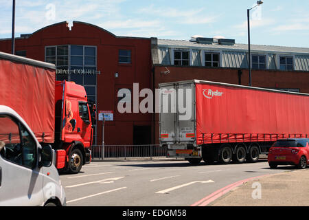 Deux camions articulés de rouge et d'autres véhicules circulant autour de Tolworth rond-point à Surrey, Angleterre Banque D'Images