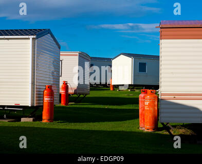 Caravanes statiques sur un site de vacances à Carnforth dans Northumberland England UK avec des bonbonnes de gaz Calor orange Banque D'Images