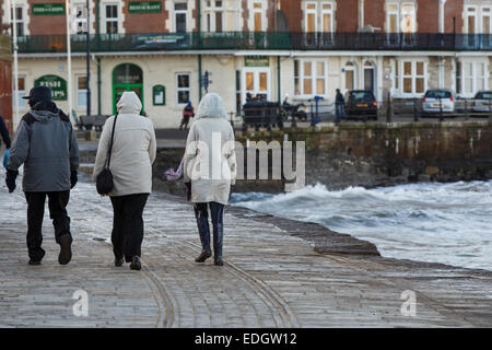 Un port de Swanage orageux - walkers braver les éléments à Swanage dans le Dorset. Des vents violents et des mers agitées. Banque D'Images