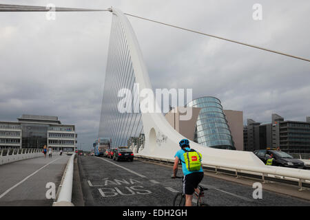 Biker sur Samuel Beckett pont traversant la rivière Liffey et le Centre de Convention sur Spencer Dock à Dublin Banque D'Images