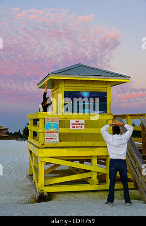 Siesta Key Beach lifeguard tower avec couple exercising au coucher du soleil à Sarasota, Floride. Banque D'Images