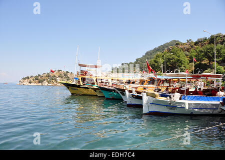 Des bateaux de tourisme en ligne de Marmaris dans le port de Turunc tandis que les touristes visiter le marché local. Banque D'Images