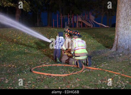 Un jeune garçon sur une ligne de tuyau d'incendie à l'échelle nationale nuit à Richfield WI Banque D'Images