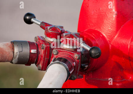 Poteau rouge et hoselines attaché avec soupapes Banque D'Images