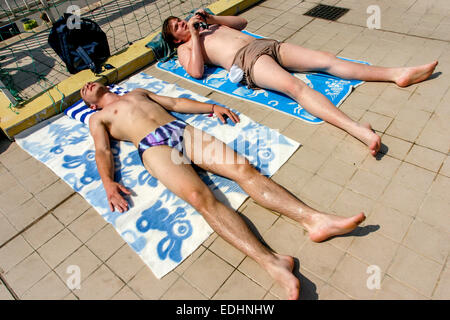 Bains de soleil à la piscine bains de soleil de chaleur d'été Banque D'Images
