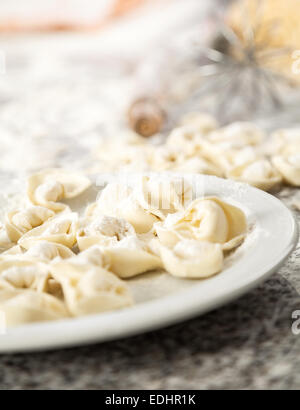 Raviolis crus pâtes dans la plaque sur le plan de travail Banque D'Images