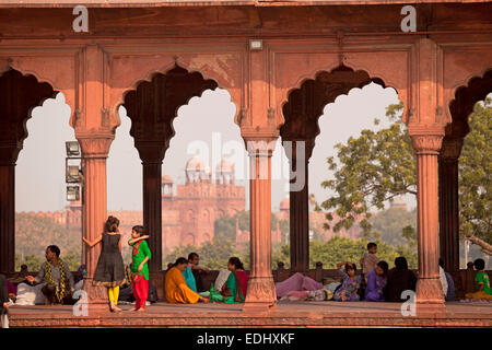 Colonnade dans la cour de la mosquée de vendredi Jama Masjid, le Fort Rouge à l'arrière, Delhi, Inde Banque D'Images