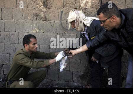 Sanaa, Yémen. Jan 7, 2015. Un policier recueille des éléments de preuve à l'explosion site dans Sanaa, Yémen, le 7 janvier 2015. Au moins 50 personnes ont été tuées et 20 autres blessées mercredi lorsqu'une voiture piégée a explosé à l'extérieur de l'académie de police dans la capitale du Yémen, Sanaa, des infirmiers responsables de la sécurité et a dit. Credit : Hani Ali/Xinhua/Alamy Live News Banque D'Images