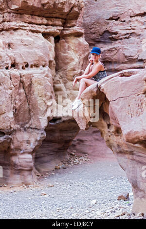 Belle fille assise sur un rocher dans la région de Canyon rouge Banque D'Images