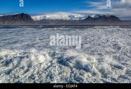 Vue aérienne de vagues déferlantes et Eyjafjallajokull Glacier en arrière-plan, Côte Sud, Islande Banque D'Images