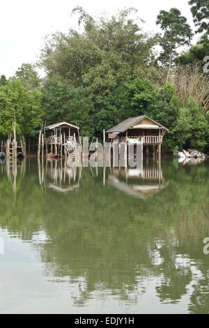 Maisons sur pilotis, rivière avec bateaux longtail, mangrove, de la rivière Krabi, Thaïlande, Asie du sud-est. Banque D'Images