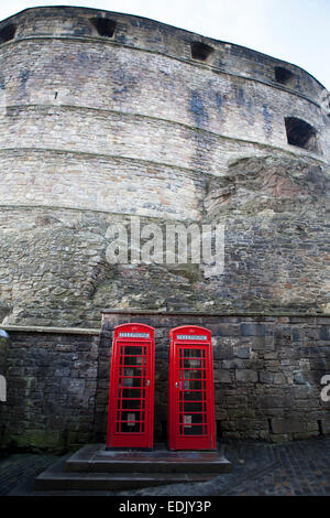 Deux boîtes de téléphone britannique rouge emblématique sous le mur historique du Château d'Édimbourg, en Écosse. Banque D'Images