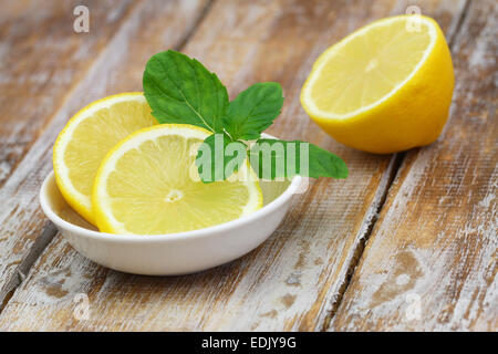 Garni de citron feuilles de menthe biologique sur la surface en bois rustique Banque D'Images