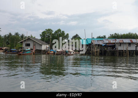 Maisons sur pilotis, rivière avec bateaux longtail, mangrove, de la rivière Krabi, Thaïlande, Asie du sud-est. Banque D'Images