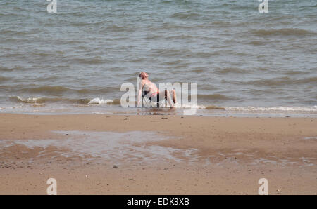 Homme assis sur petite chaise de plage sur la mer sur une journée d'été, Clacton-on-Sea Banque D'Images