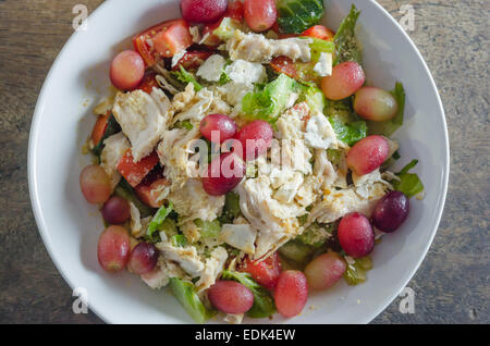 Mélanger avec la salade de poulet et les raisins sur le plat blanc Banque D'Images