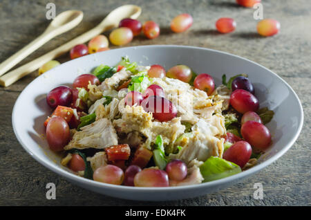 Mélanger avec la salade de poulet et les raisins sur le plat blanc Banque D'Images