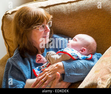 Une grand-mère berçant un bébé âgé d'un mois dans ses bras. Banque D'Images