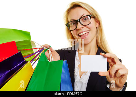 Femme heureuse avec de nombreux sacs de magasinage la tenue d'une carte de crédit vide Banque D'Images