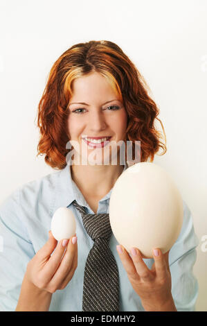 Femme à l'occasion de deux oeufs de taille moyenne Banque D'Images