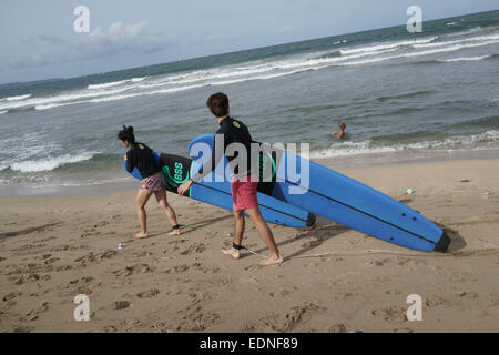 Les touristes du surf à la plage de Kuta, Bali Indonésie. Kuta est l'une des plages les plus populaires dans le monde. Banque D'Images