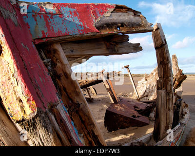 Vieux bateau en bois dans le sable en décomposition sur le bord de la rivière Taw sur le bord de Braunton Burrows, Devon, UK Banque D'Images