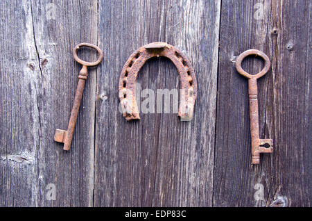 Deux old rusty key historique et symbole de chance à cheval sur un mur de ferme en bois Banque D'Images