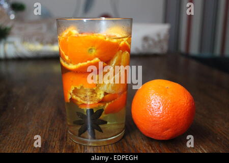 Vitamine fruits lumineux en verre de boisson et une orange mandarin séjour sur table Banque D'Images