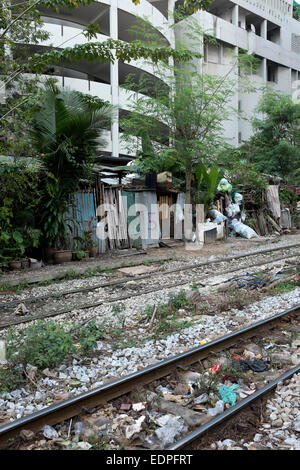 Shanty maisons avec portes numérotées à côté des voies de chemin de fer près de Siam Square, au centre-ville de Bangkok Banque D'Images