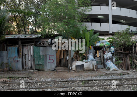 Shanty maisons avec portes numérotées à côté des voies de chemin de fer près de Siam Square, au centre-ville de Bangkok Banque D'Images