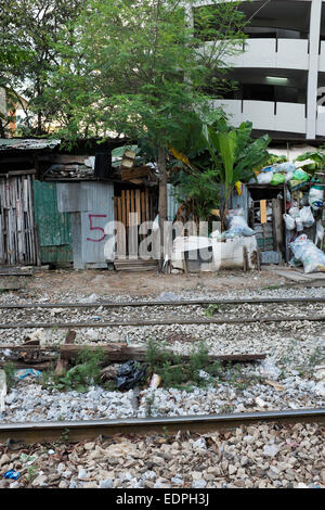 Shanty maisons avec portes numérotées à côté des voies de chemin de fer près de Siam Square, au centre-ville de Bangkok Banque D'Images