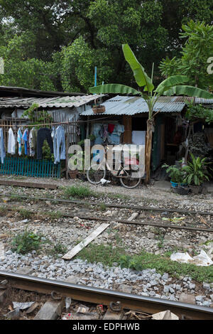 Maisons bidonvilles aux côtés des rails de chemin de fer près de Siam Square, au centre-ville de Bangkok Banque D'Images