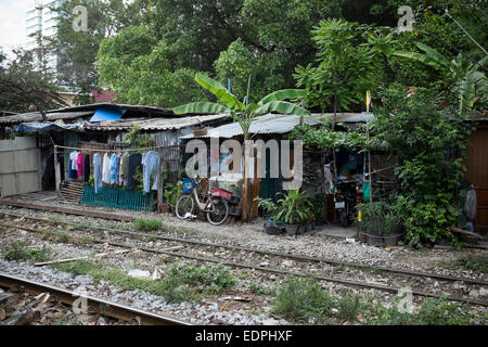 Maisons bidonvilles aux côtés des rails de chemin de fer près de Siam Square, au centre-ville de Bangkok Banque D'Images