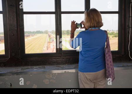 La prise d'une photo de touriste à la recherche vers le bas de la tour d'entrée au camp de concentration d'Auschwitz-Birkenau, Auschwitz, Pologne Banque D'Images