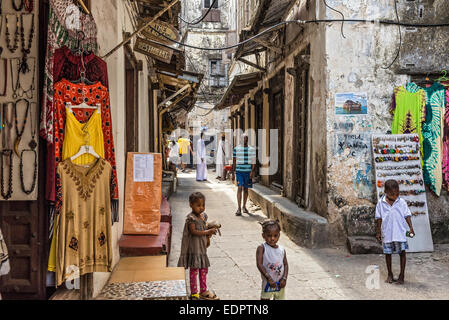 La population locale sur une ruelle typique de Stone Town, Zanzibar Banque D'Images