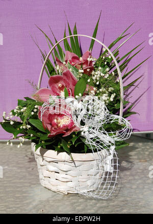 Bouquet de fleurs dans le panier de blanc sur la table. Banque D'Images