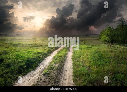 La foudre et storm clouds over country road Banque D'Images
