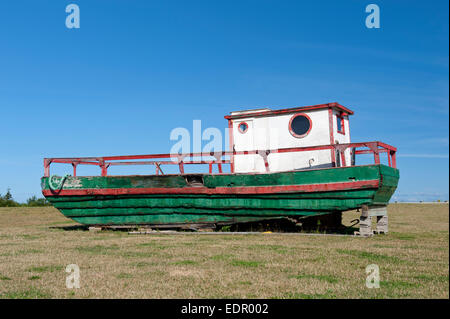 Vieux bateau de pêche en bois abandonnés dans un champ dans la région de Kamouraska, province de Québec, Canada. Banque D'Images