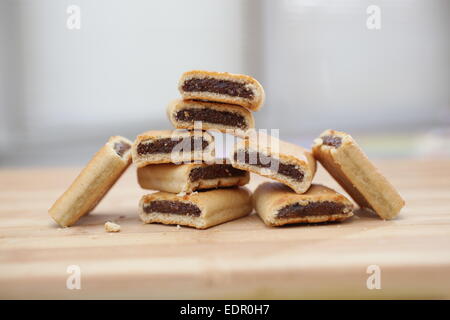 Pile de figues newtons sur une planche à découper en bois Banque D'Images