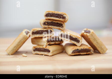 Pile de figues newtons sur une planche à découper en bois Banque D'Images