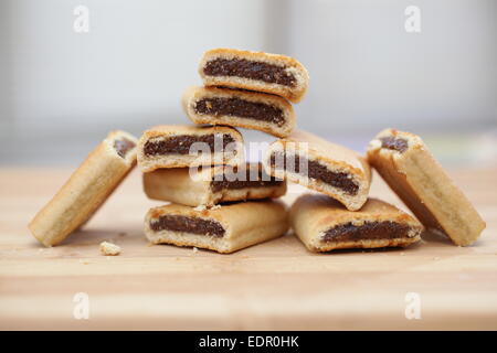 Pile de figues newtons sur une planche à découper en bois Banque D'Images