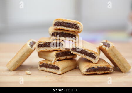 Pile de figues newtons sur une planche à découper en bois Banque D'Images