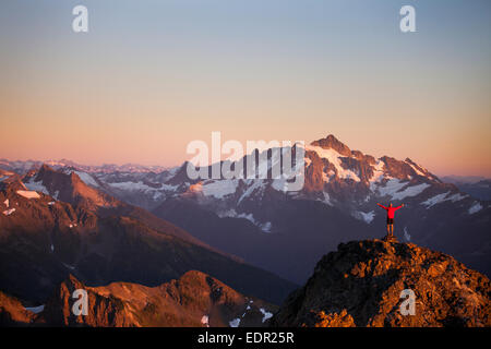 Un randonneur se dresse sur une crête rocheuse dans la région de North Cascades National Park. Banque D'Images