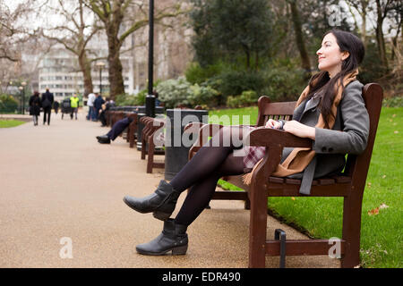 Jeune femme assise dans le parc Banque D'Images