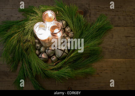 Couronne de Noël vert naturel avec des bougies et centres de cloches sur une table en bois rustique Banque D'Images