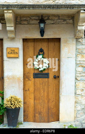 Bois de chêne traditionnel anglais porte avant de chalet avec flower garland au pittoresque village de Castle Combe dans l'Cotswo Banque D'Images